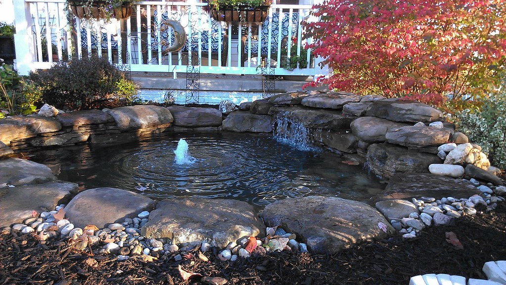 Pond installation by a deck with a fountain Pondscaped Maryland