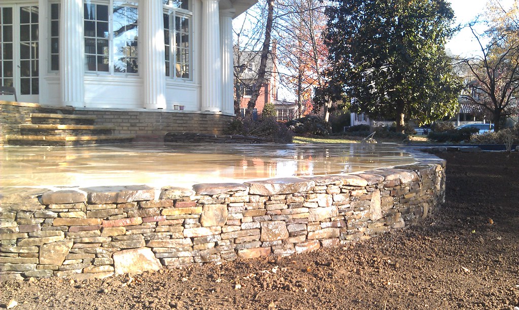 Backyard pond by custom patio