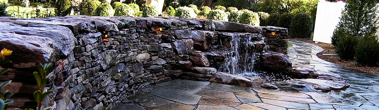 Stone walkway with a waterfall wall.